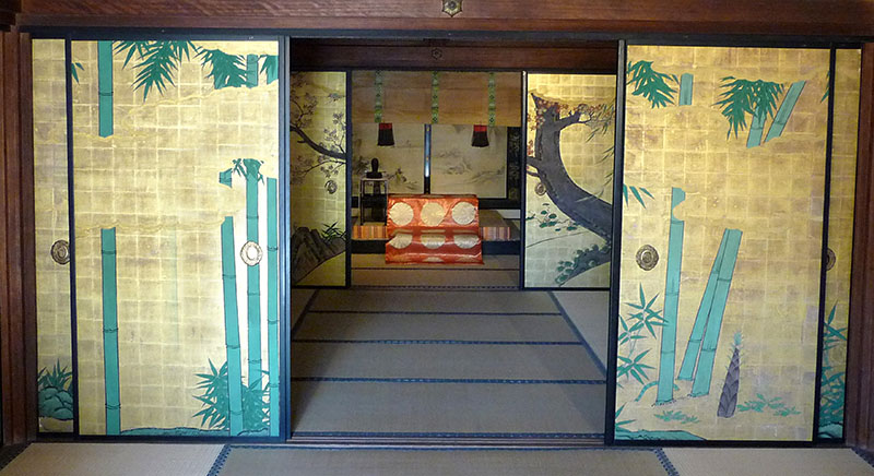 Blick in ein Gebäude, das die besondere Innenarchitektur traditioneller japanischer Bauweise mit Schiebewänden erkennen lässt. 